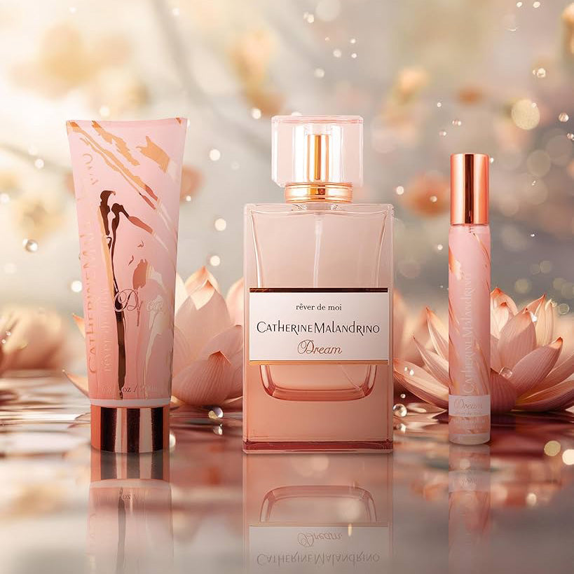 Catherine Malandrino perfume set with a pink and rose gold design on a blurred floral background.